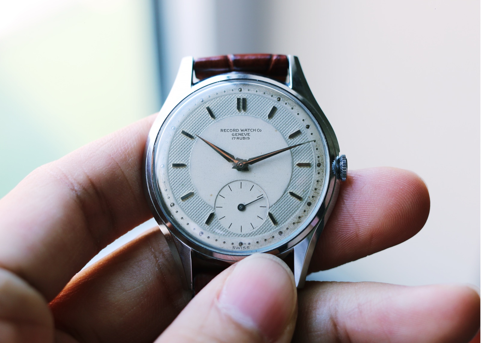Close photograph of the Record Genève waffle-dial watch held in hand